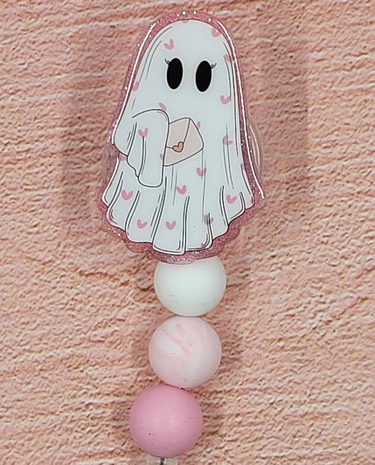 Who said ghosts are scary? This ghost is dying to share heart...and spirit... with you in our new Valentine Ghost Badge Reel. Featuring a cute ghost holding a Valentine's Day card and a pink glitter base with coordinated beads, this is the perfect accessory for the holiday season.