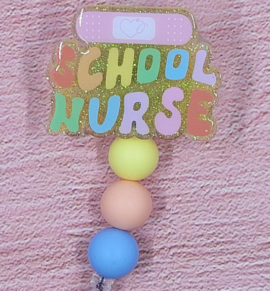 Introducing the new School Nurse Badge Reel, part of our latest collection of Medical Badge Reels available now. Featuring School Nurse with a Band-Aid and a yellow glitter base adorned with coordinating beads, this Badge Reel is sure to catch the eye.