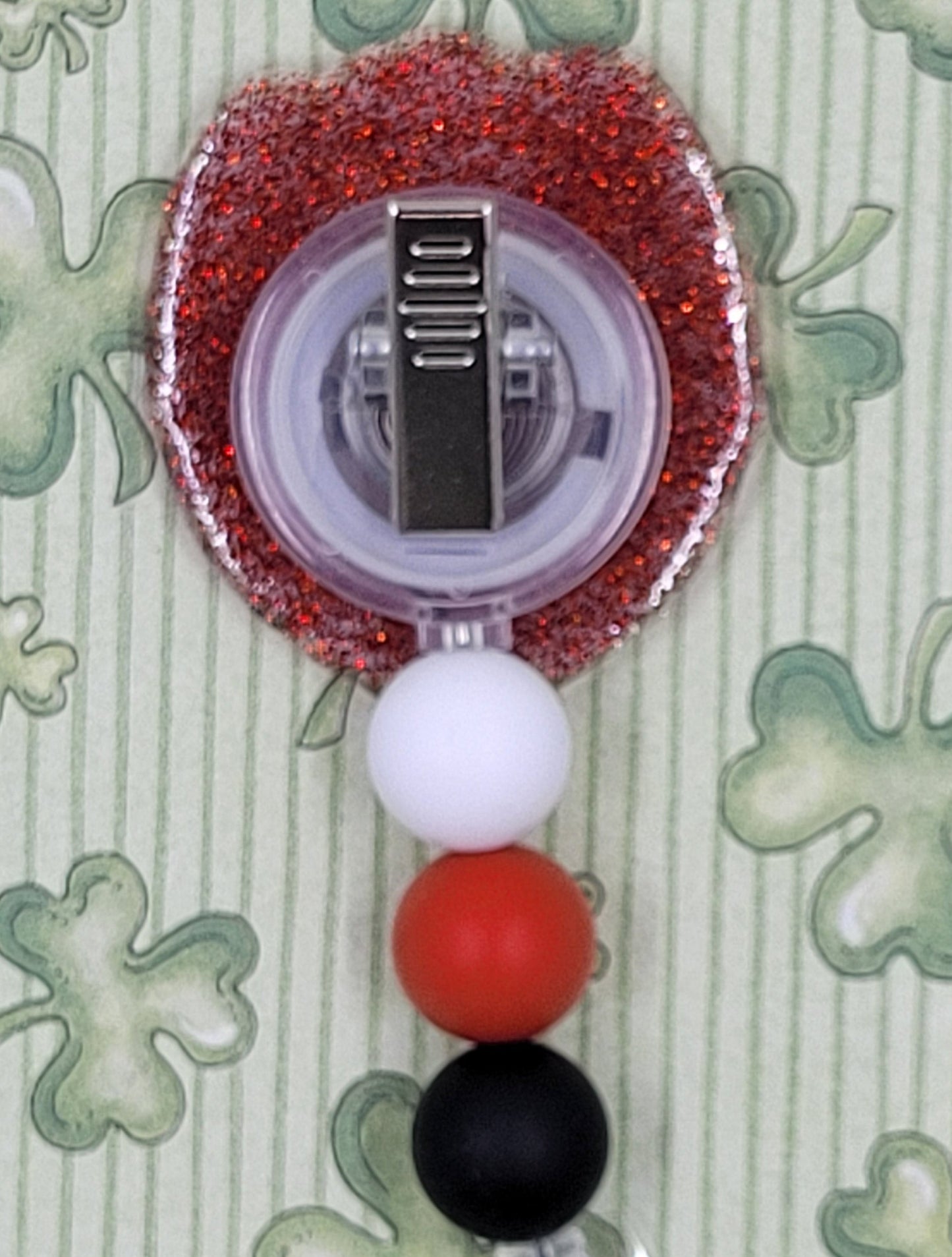 Felling Lucky? How about Luck X 3 lucky! This badge reel features 3 of the more popular lucky things. A horseshoe, a lady bug and of course a 4 Leaf Clover. A brilliant red glitter base and 3 silicone color coordinated beads finish the look.
