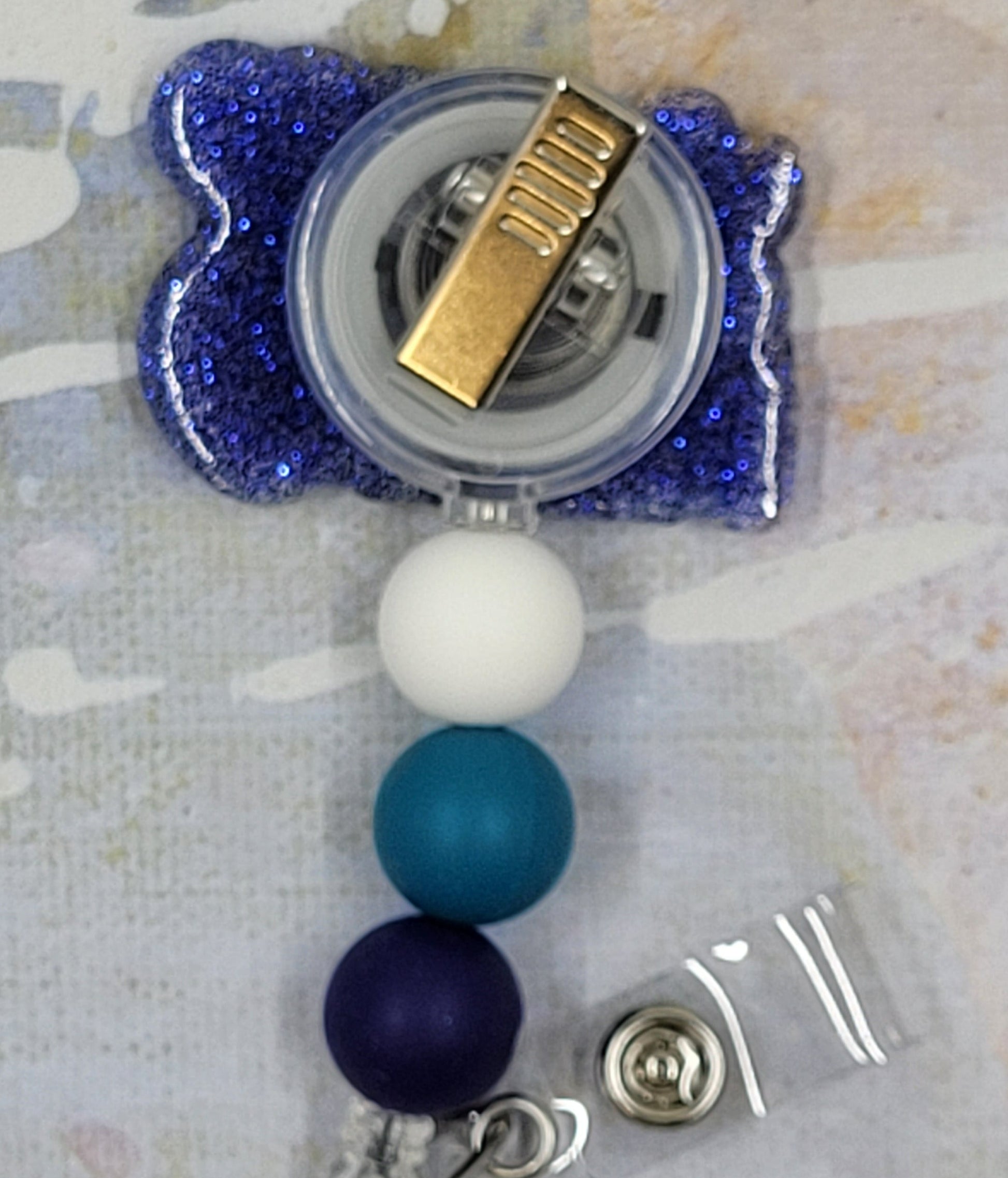 You Matter. You do and everything about you matters. This badge reel proudly promotes that statement. In blues and purples with a dark blue glitter base, this badge reel is a looker. 3 color coordinated silicone beads finish the look.