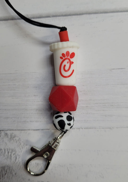 Need a custom Freshie Hanger? Here is a silicone beaded hanger we like to call Chick Fillet Drink. Has a white drink container as a focal bead with a red hexagon bead and cowhide bead to finish the look. Attaches quickly to any one of our many Freshies so you can easily hang it from your rear view mirror.