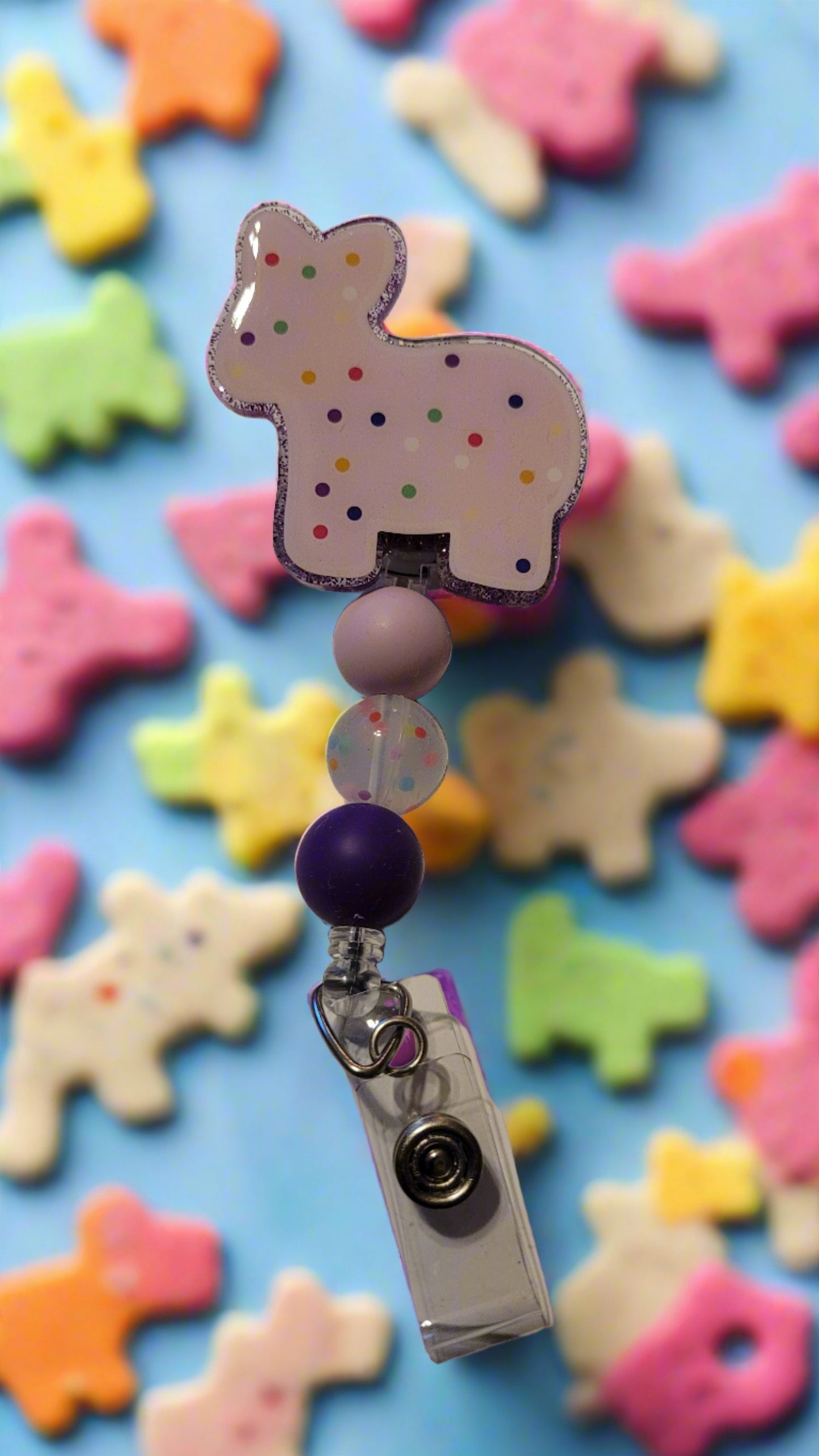 Frosted animal crackers with sprinkles are brought to life in these delicious Badge Reels! Our first offering is the stubborn yet adorable donkey - pick from a variety of colors and complementing silicone accent beads.