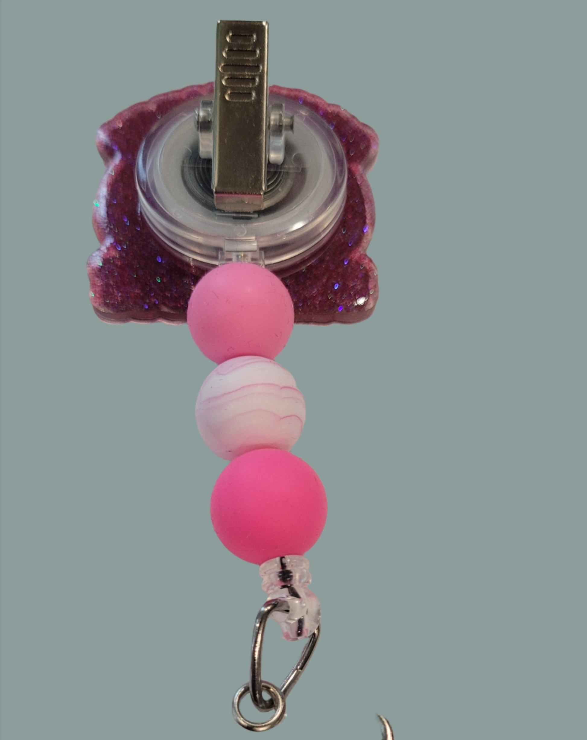 Well this could go 1 of 2 ways. Either heading to the kitchen to Stir The Pot or your on the way to cause some trouble and Stir the Pot that way. Either way this cute acrylic badge reel features a pink glitter back and 3 color coordinated silicone beads.