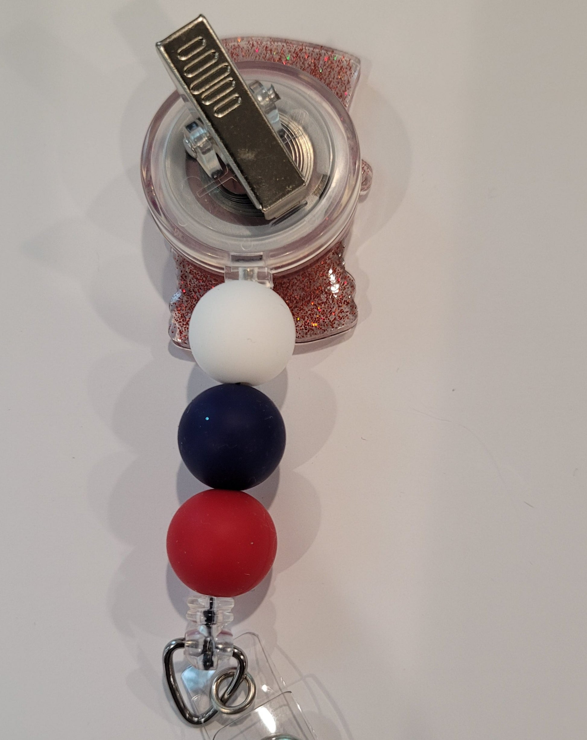 This playful badge reel features an adorable Patriotic Gnome channeling Uncle Sam, complete with a heart in hand. The design is topped off with a sparkly red backing and patriotic red, white, and blue silicone beads.