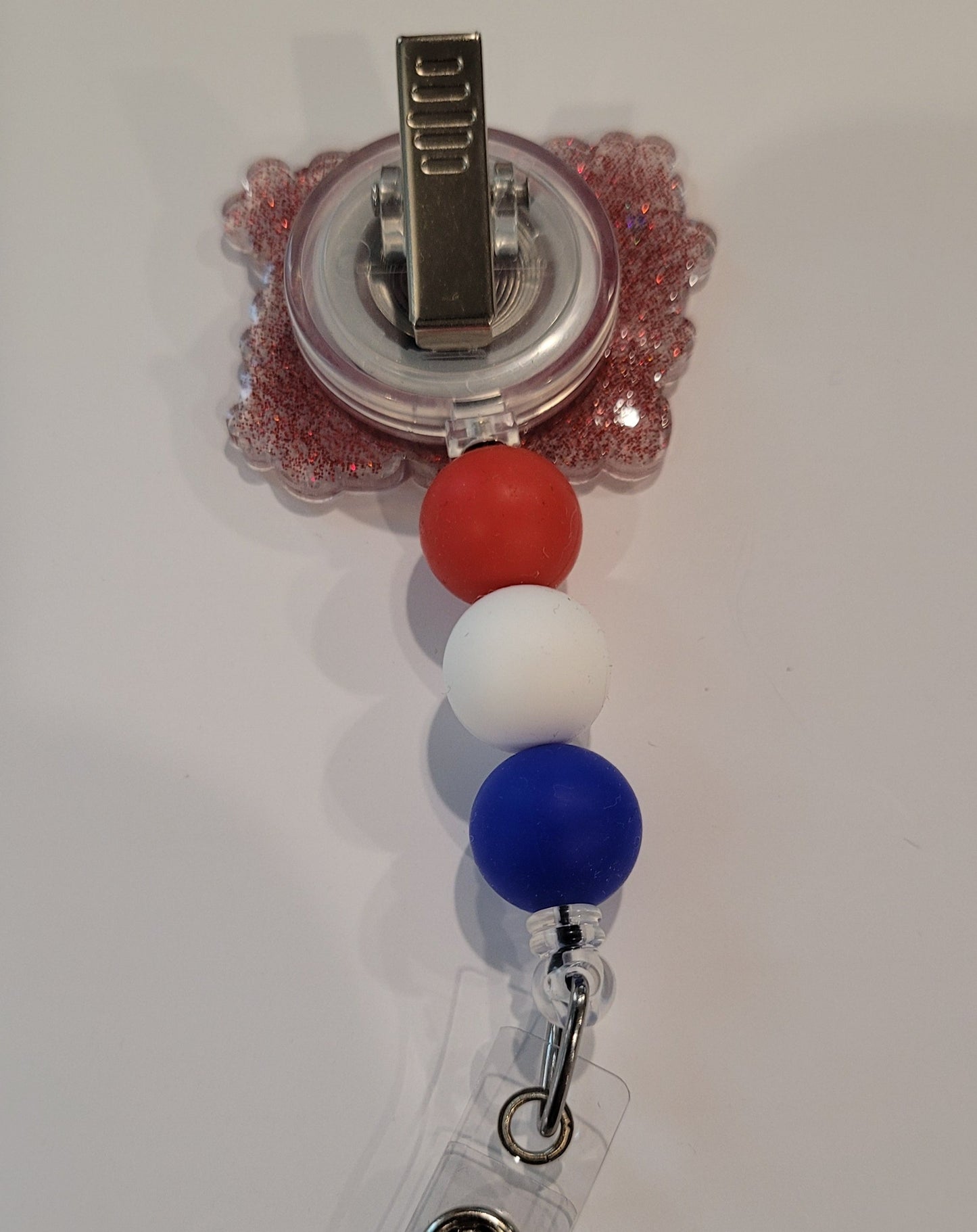 Oh My Stars &amp; Stripes! Adding a touch of patriotism, this badge reel flaunts red, white, and blue silicone accent beads and a red glitter back. Perfect for showing your patriotism.