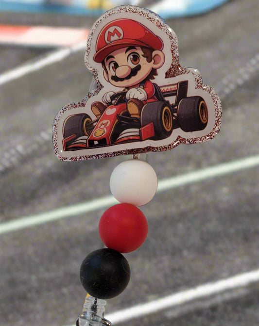 Join the fun and meet your new hero, the "Red Plumber" badge reel! This playful accessory features a red glitter back and 3 matching silicone beads for a quirky and stylish look.