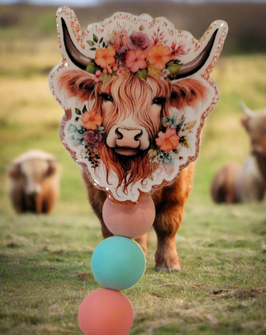 The classic Highland Cow is here in a floral theme. Surrounded by flowers and wearing a floral crown this acrylic badge reel will put a smile on any animal lovers face. An orange glitter back and 3 silicone beads finish the look.