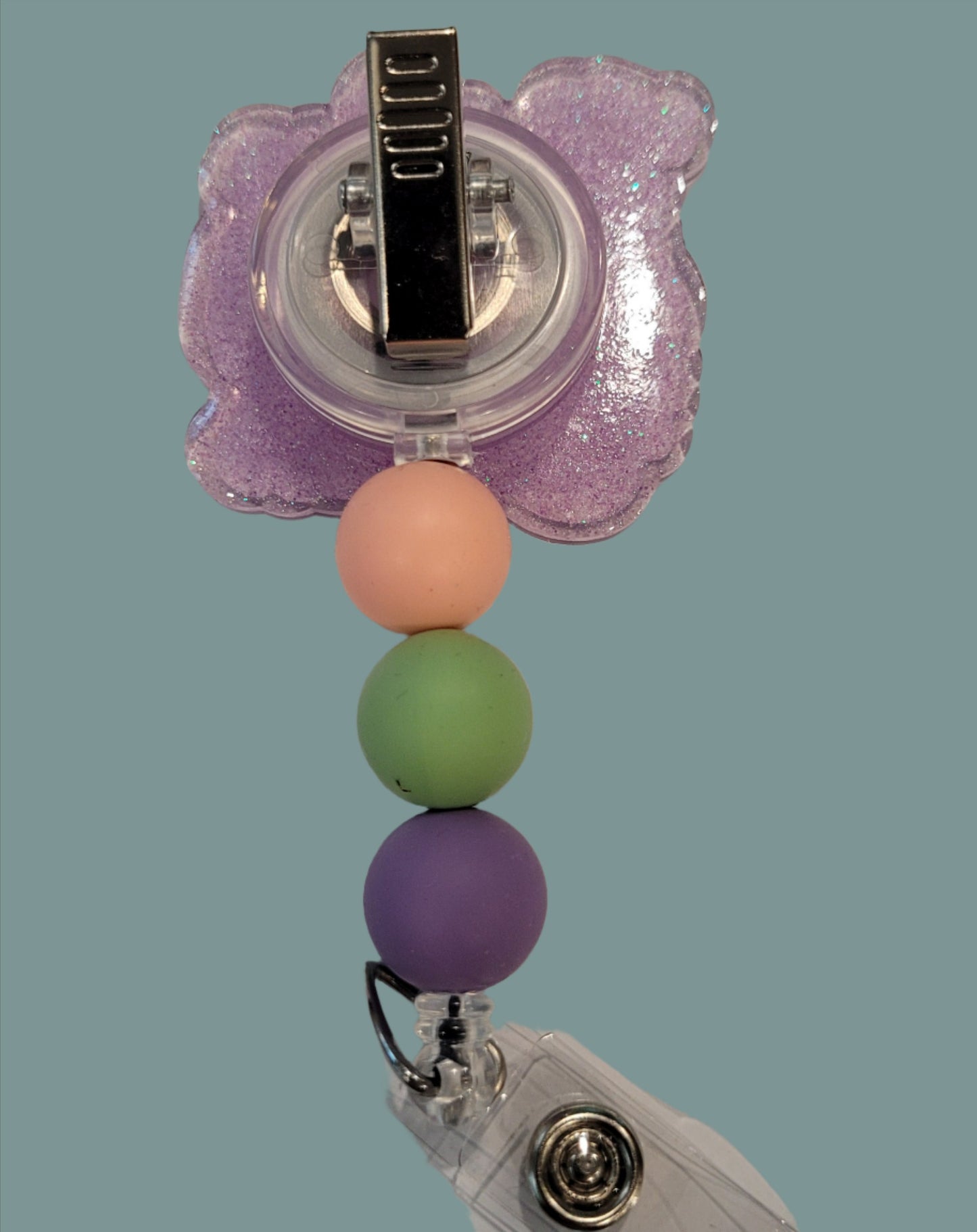 Ahhh the beach life. Here we have our acrylic badge reel stating No One Likes a Shady Beach. But what if we were located on a beach???? Quite the Paradox. This badge reel has a light purple glitter back and 3 silicone color coordinated beads to finish the look.