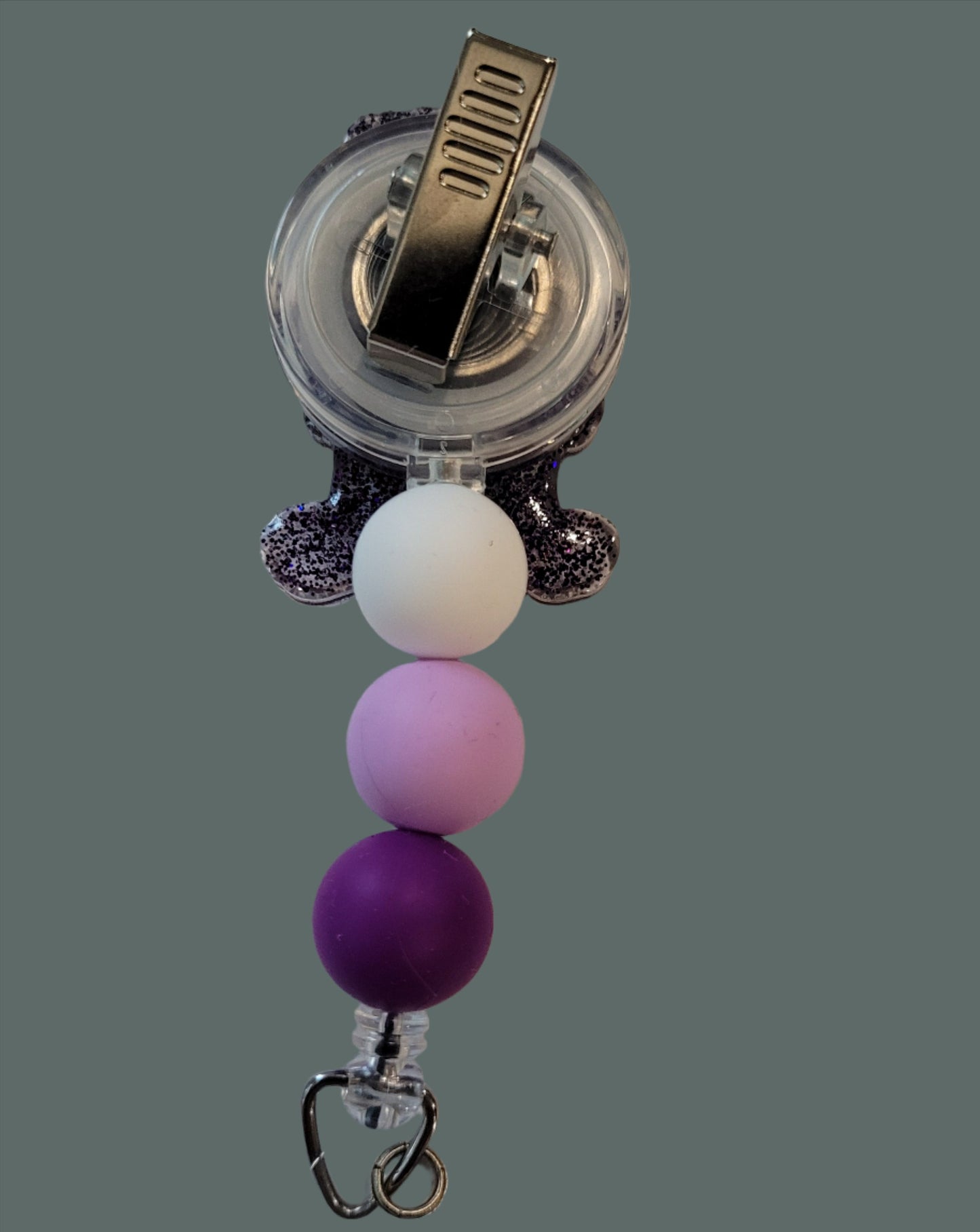 Looking for a charming badge reel? Well, look no further because we've got our Share&nbsp; Bear here! With a glittery purple back and 3 matching silicone beads, it's perfect for all the bear lovers out there. This is 1 of 5 variations.