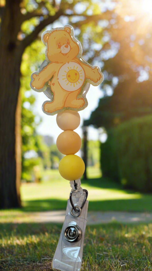 Looking for a charming badge reel? Well, look no further because we've got our Funshine&nbsp; Bear here! With a glittery yellow back and 3 matching silicone beads, it's perfect for all the bear lovers out there. This is 1 of 5 variations.