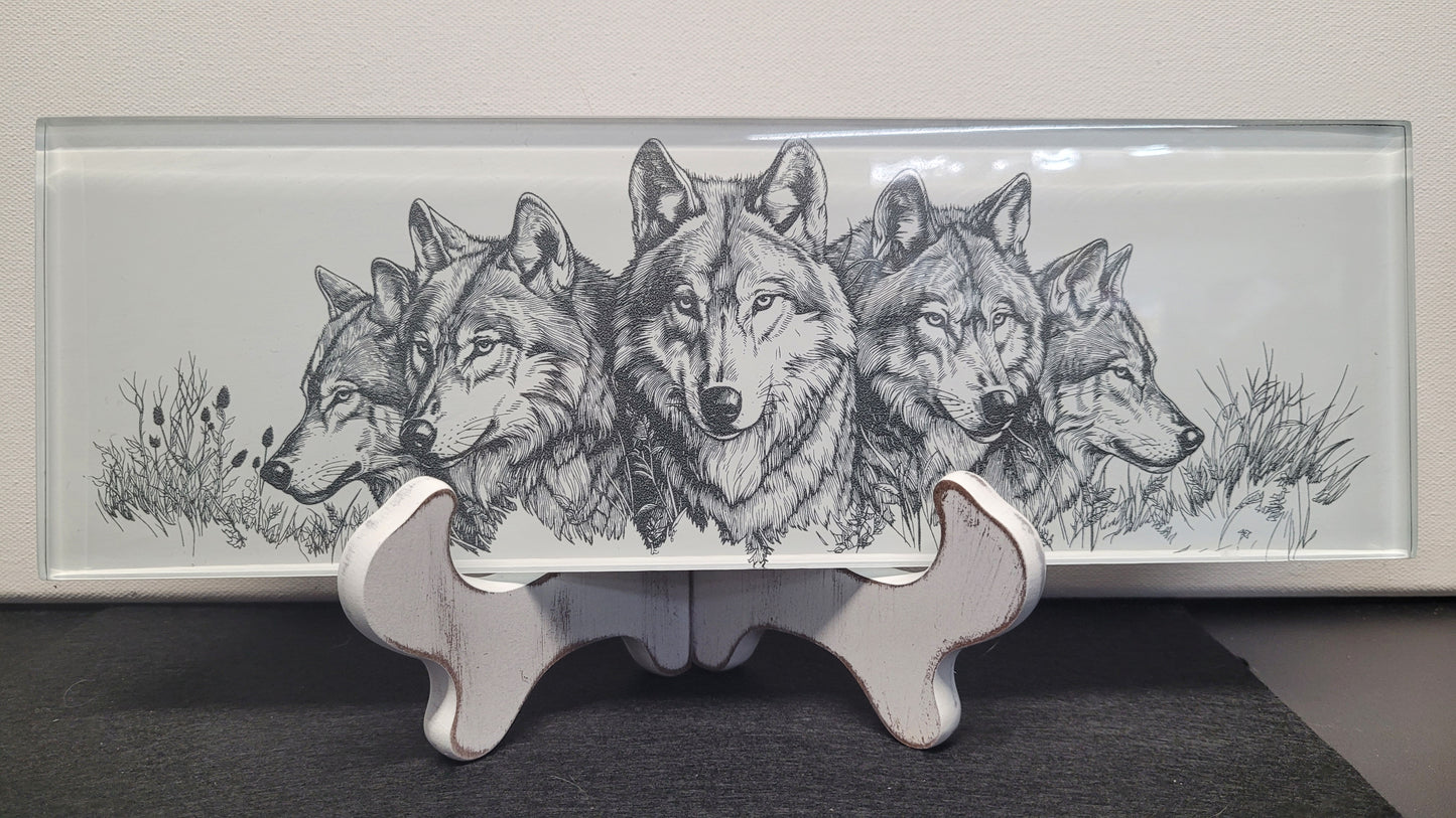 This basic glass wall tile as been transformed into a beautiful laser engraved wolf collage image. The fine detail from the laser really shines through on the white background. Measuring 4" tall x 12" wide and 1/4" thick, this tile is a strong sturdy piece. Black felt backing allows you to display flat on a table or use the white washed wooden easel that comes with it. You could even use in a remodel and put in a tiled wall if you so choose or display it for yourself or a gift for family or friend,