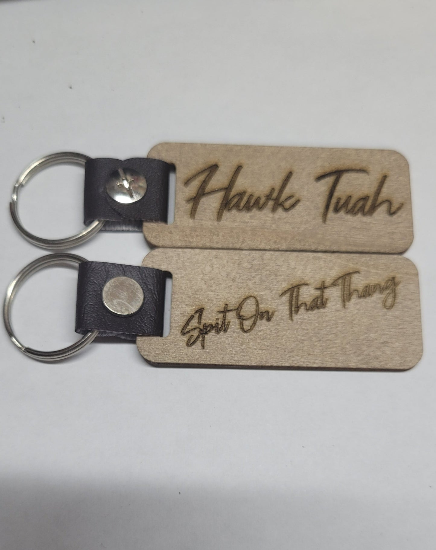 This Laser Engraved wood key chain sports the latest phrase.... Hawk Tuah.  This on the front and Spit on That Thang on the back.  For a fun novelty gift.... a must have