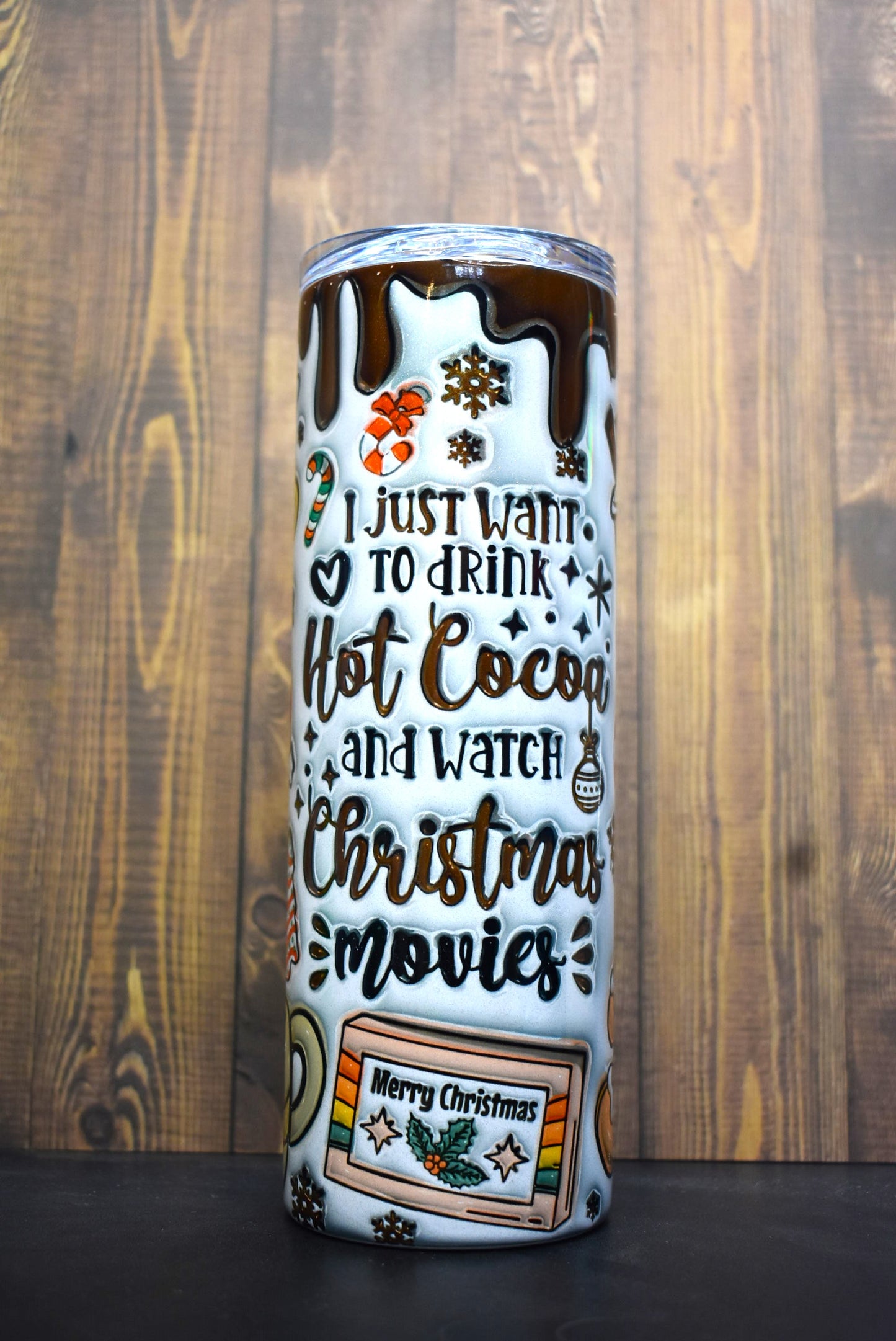 The ultimate Christmas Season tumbler here with the phrase " I Just Want To Drink Hot Cocoa And Watch Christmas Movies. A unique 3-D printed design featuring cups of hot cocoa, gingerbread cookies and various classic Christmas time snacks.