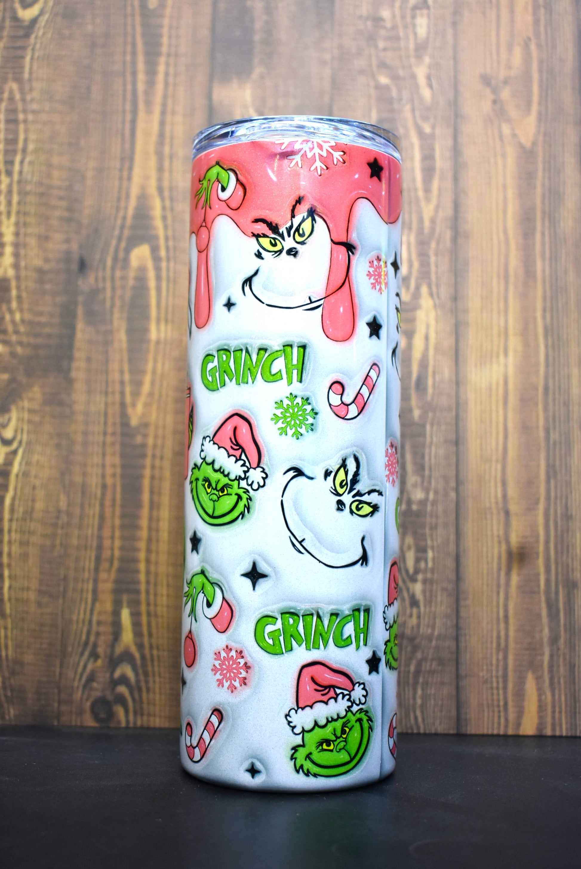 Our old friend the Grinch here in a pink coat and Christmas stocking hat. Is the smirk on his face from the drink he has in his hand or thoughts of how to steal Christmas. This unique 3-D printed design on a holographic tumble is a definite an eye catcher.