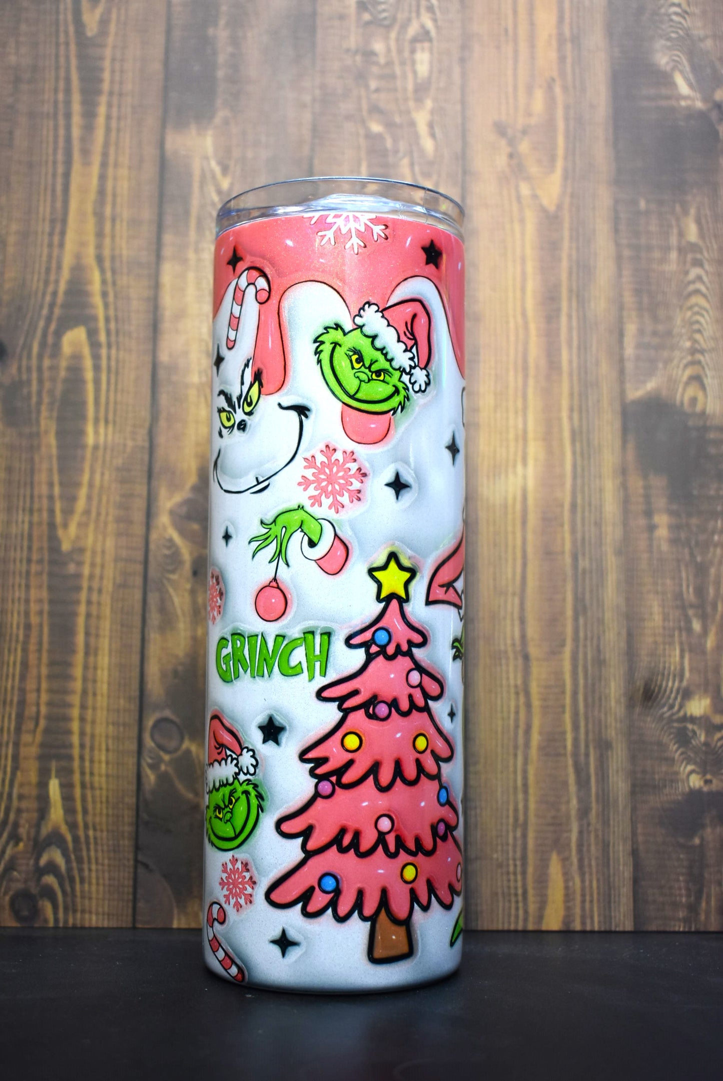 Our old friend the Grinch here in a pink coat and Christmas stocking hat. Is the smirk on his face from the drink he has in his hand or thoughts of how to steal Christmas. This unique 3-D printed design on a holographic tumble is a definite an eye catcher.