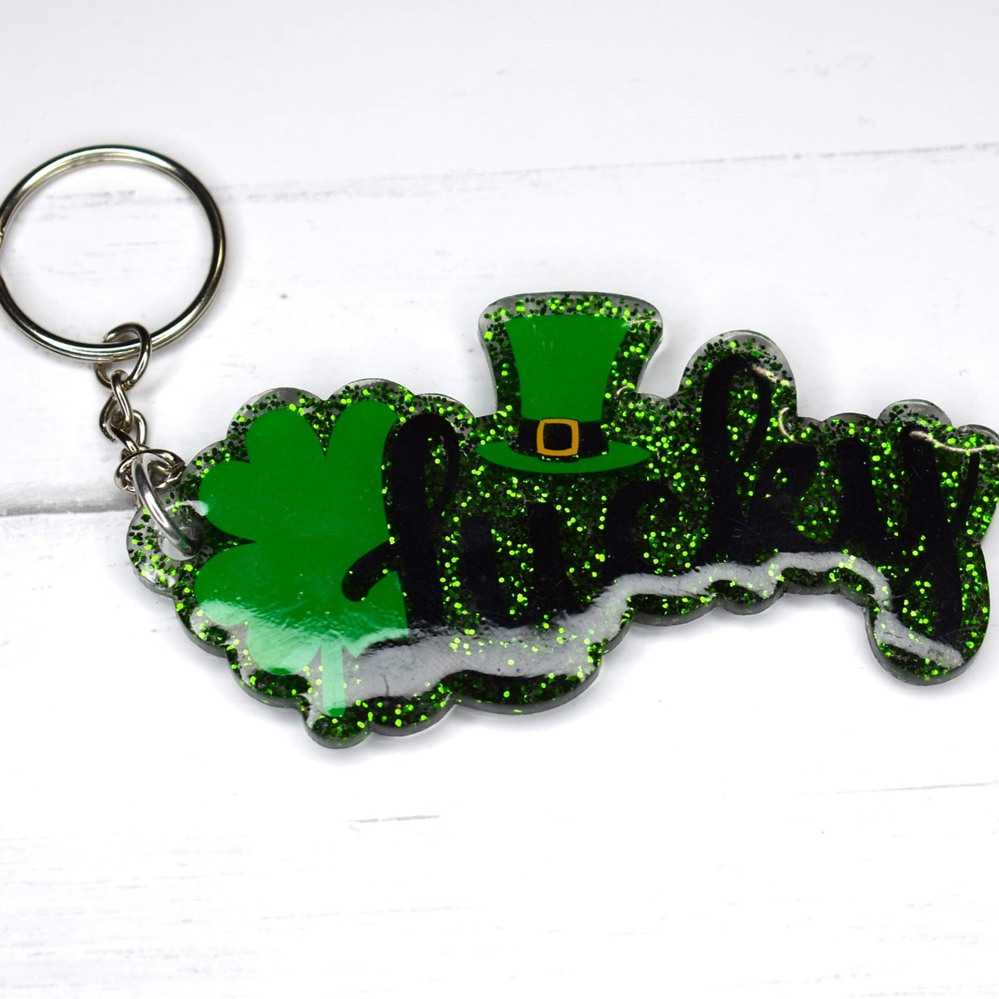 This keychain is made of acrylic resin and features a lucky Irish design. It comes in two options: a green glitter background or a sparkling clear glitter background. Show off your luck today!