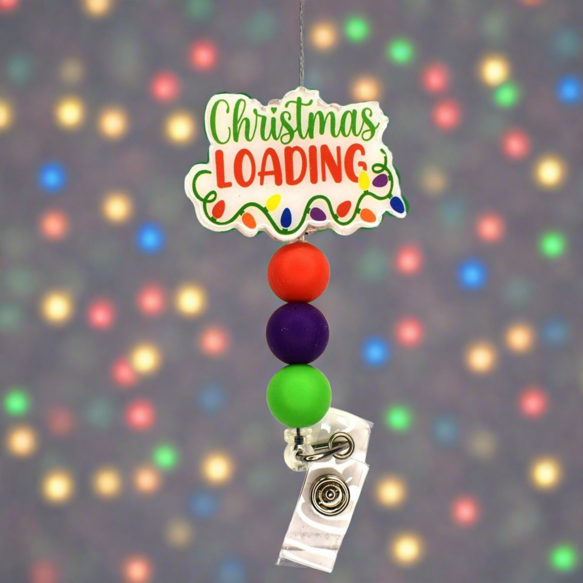 The internet is overloaded and speeds are slowing as Christmas is Loading. This cute badge reel features a glitter base with the phrase Christmas Loading and a string of festive lights.  3 color coordinating silicone beads finish the look.