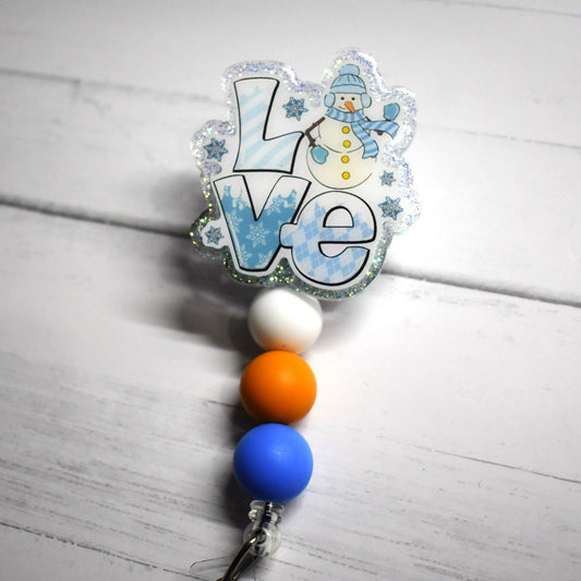 Love...Snow, Winter, Snowmen...Any of these for you? Then this badge reel would Love to be yours. The word Love with a happy snowman waving is featured with a blue glitter back ground finished with white orange and a blue silicone beads.