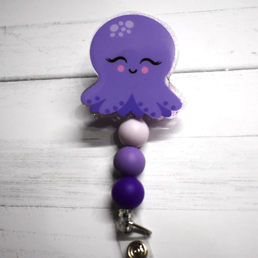 This isn't just Squid Games--it's a delightful Purple Octopus with cheerful pink cheeks and an inviting smile. The design is completed with three different shades of purple silicone beads.