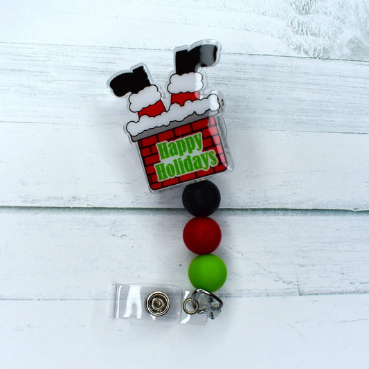 Uncover the mystery of the chimney with this acrylic badge reel adorned with the boots of Santa Claus. An array of 3 different colors of silicone beads are available to customize your design.