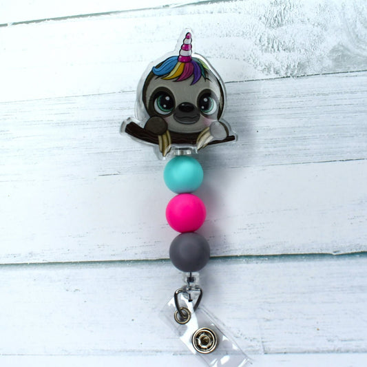 Boasting our unique Sloth signature, the Slothicorn acrylic badge reel is a delightful combination of a Sloth and Unicorn. Adorned with teal, pink, and grey silicone beads, this mythical creature is sure to excite.