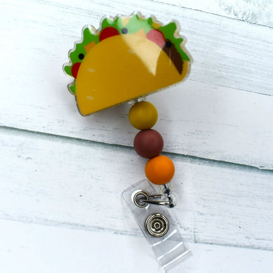 This alluring acrylic badge reel provides a hard shell taco with all the desired additions, and is concluded with complimentary silicone beads for an eye-catching meal-like appeal.