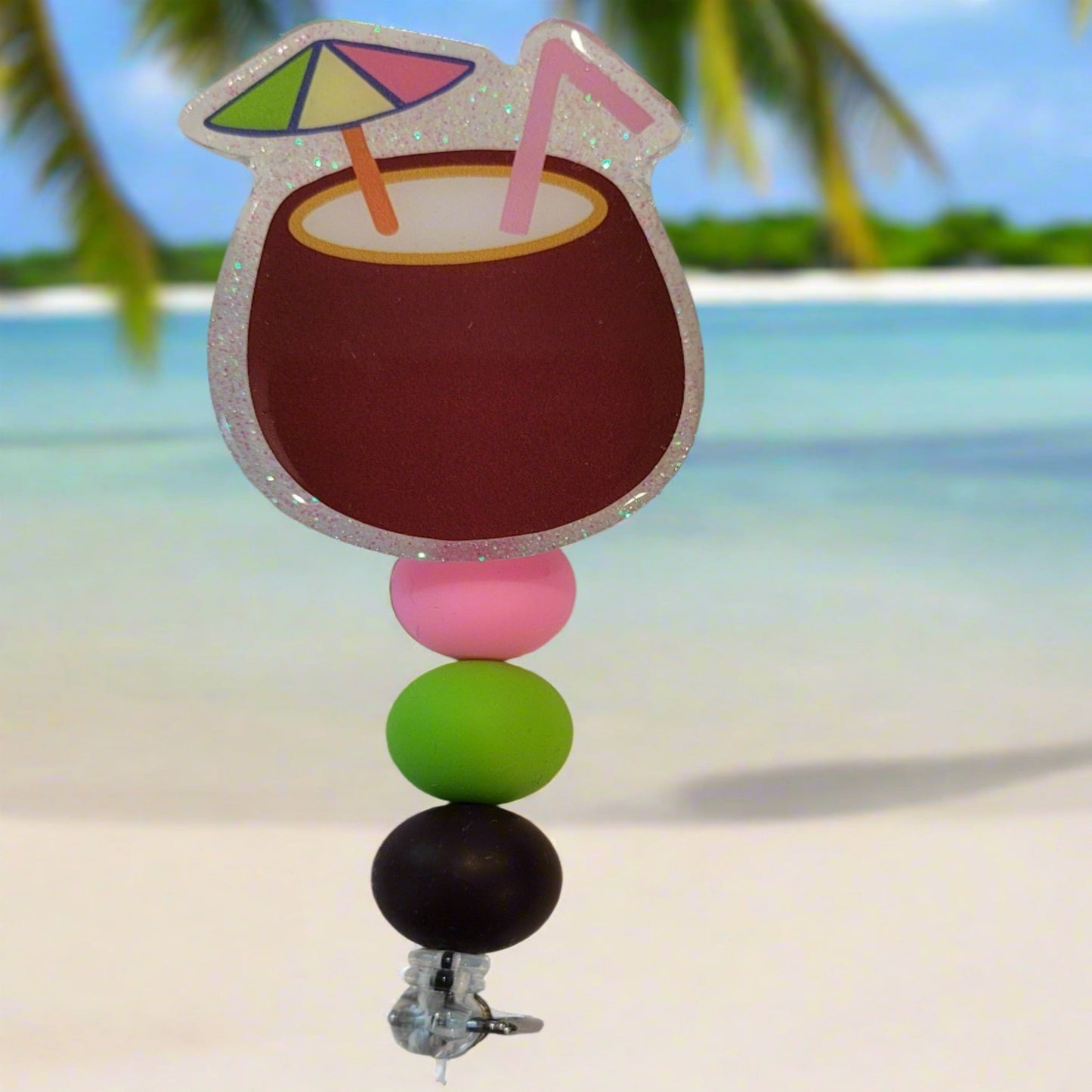 Enjoy this tasty Caribbean Cocktail Badge Reel that any rum lover would be happy to have. Sporting a drink in a coconut shell with umbrella &amp; straw, glitter back and 3 color coordinated silicone beads to finish the look. Last Call!&nbsp;