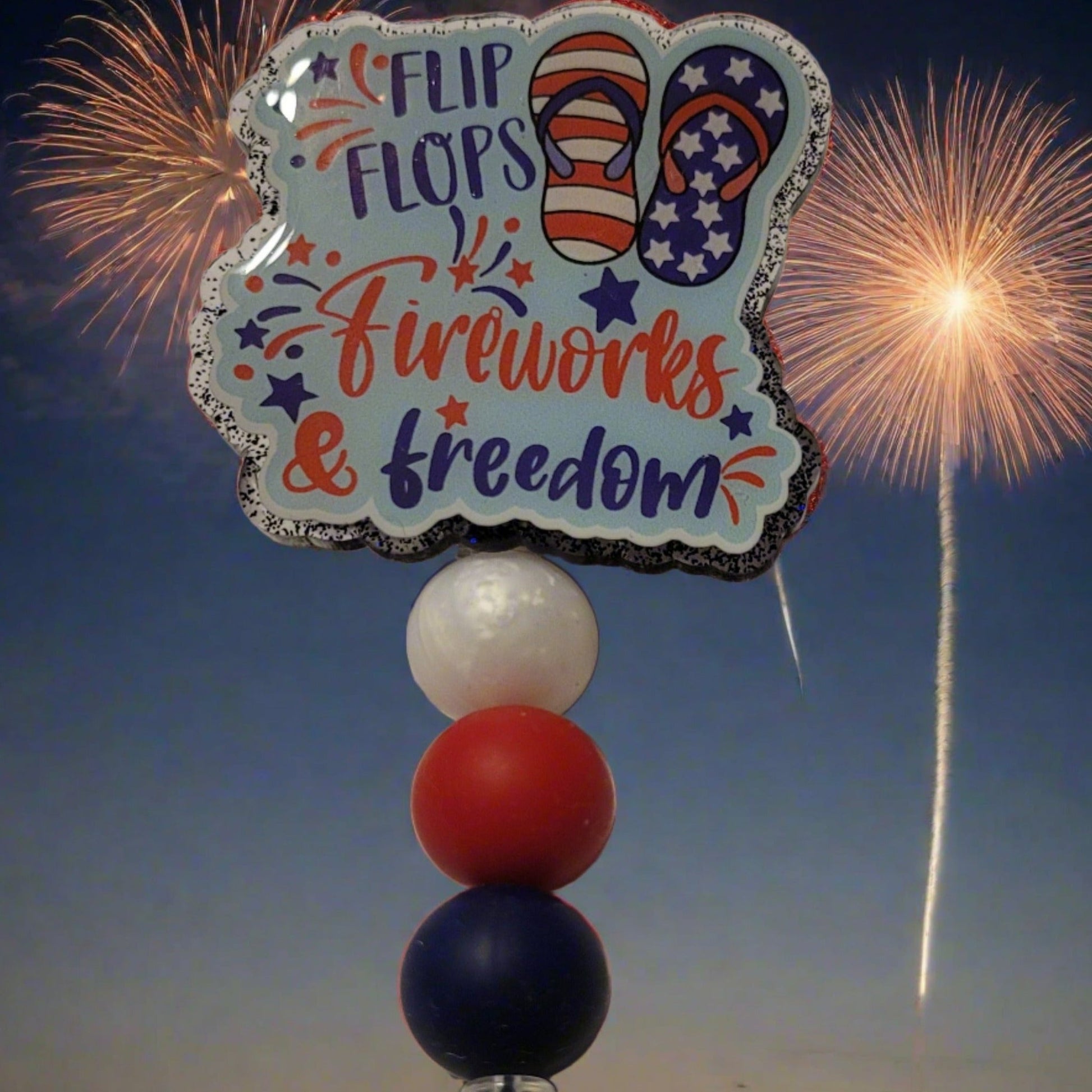 Experience the ultimate summer vibe with these Flip Flops &amp; Fireworks! Adding a touch of patriotism, this badge reel flaunts red, white, and blue silicone accent beads, perfect for watching the fireworks on National Holidays.