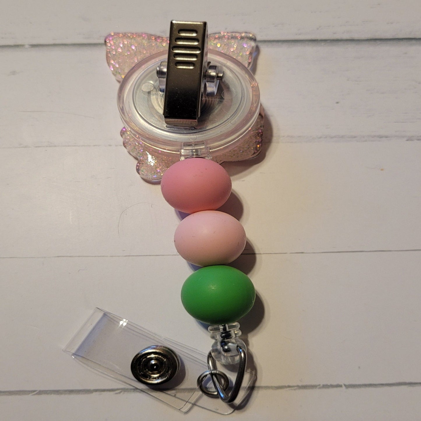 Unleash your inner whimsy with this delightful Badge Reel starring a charming little Floral Piggy, complete with flower-festooned head band and a sparkling pink backdrop. And don't forget the adorable trio of matching silicone beads for a dash of extra charm. Perfect for all animal enthusiasts!