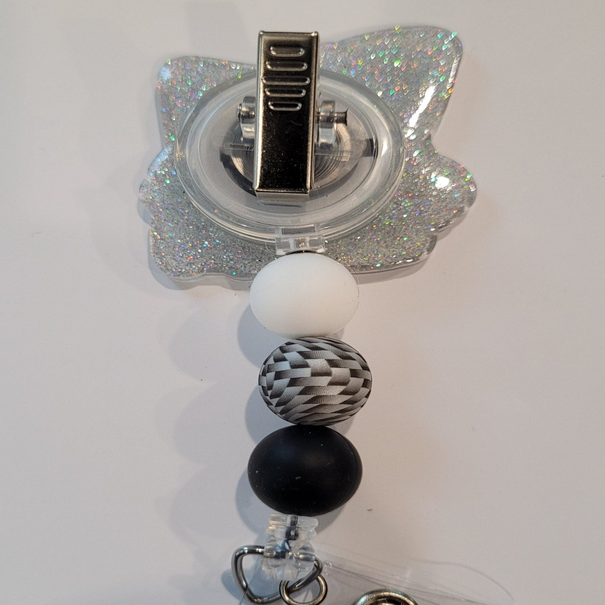 Introducing the new Gnome X-Ray Tech Badge Reel, part of our latest collection of Medical Badge Reels available now. Featuring a cute Gnome examining an X-Ray dressed in shades of gray and a silver glitter base adorned with silver black &amp; white 3d visual bead and s more color coordinating beads, this Badge Reel is sure to catch the eye.