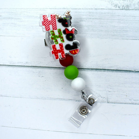 The HO HO HO acrylic badge reel features a vibrant red, green, and white design, sure to put you in a seasonal spirit.