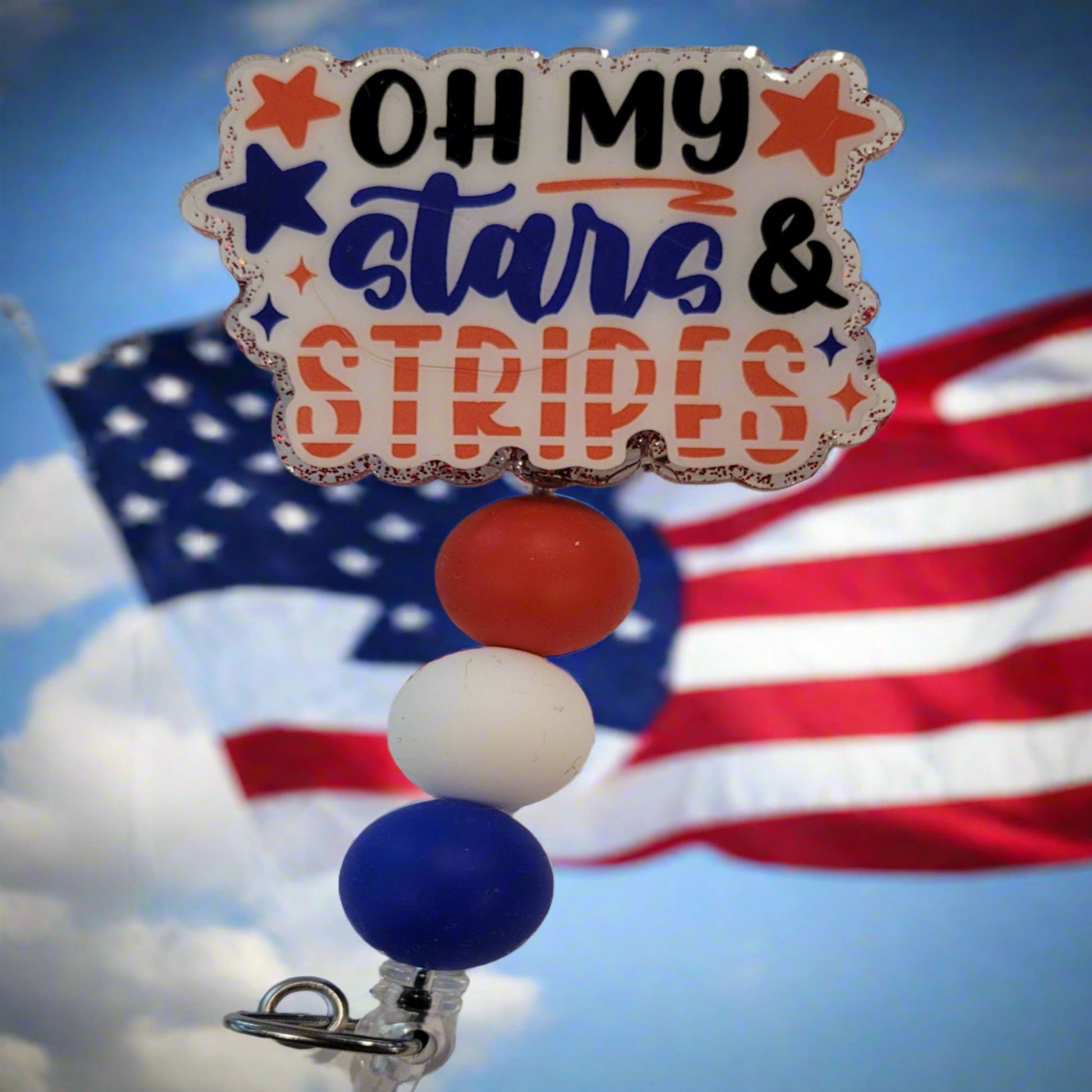 Oh My Stars &amp; Stripes! Adding a touch of patriotism, this badge reel flaunts red, white, and blue silicone accent beads and a red glitter back. Perfect for showing your patriotism.