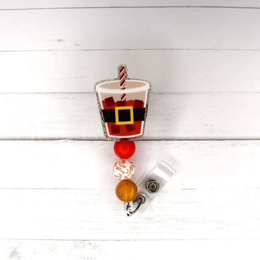 Even Santa needs a break once in awhile with a hot cocoa. This badge reel features a glitter base with a candy cane focal bead, 2 other matching silicone beads and even a big black belt with gold buckle and a peppermint straw.