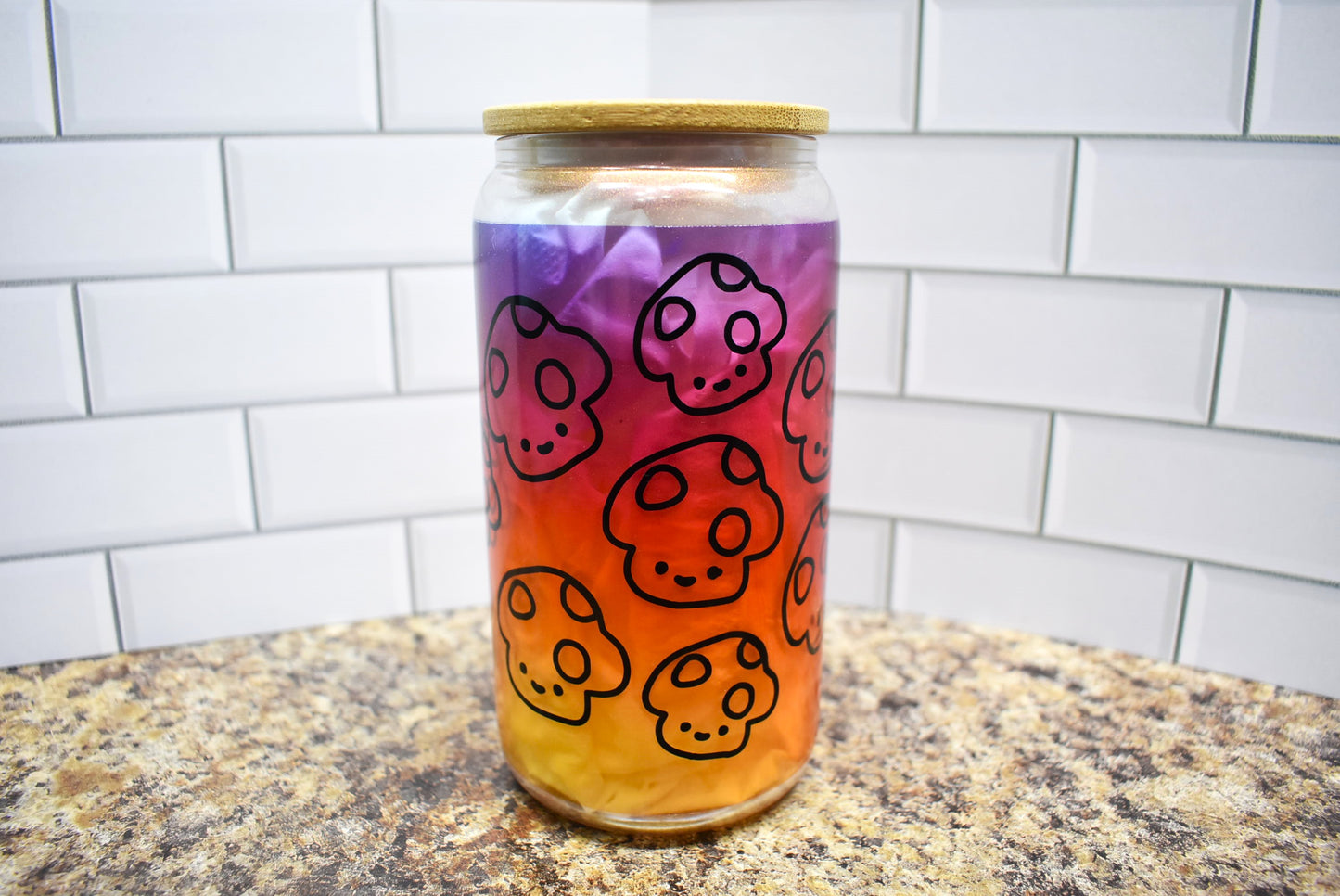 Happy Mushrooms with a beautiful orange to purple gradient background on a Pink Shimmer frosted 16 oz glass can tumbler with straw and lid. 