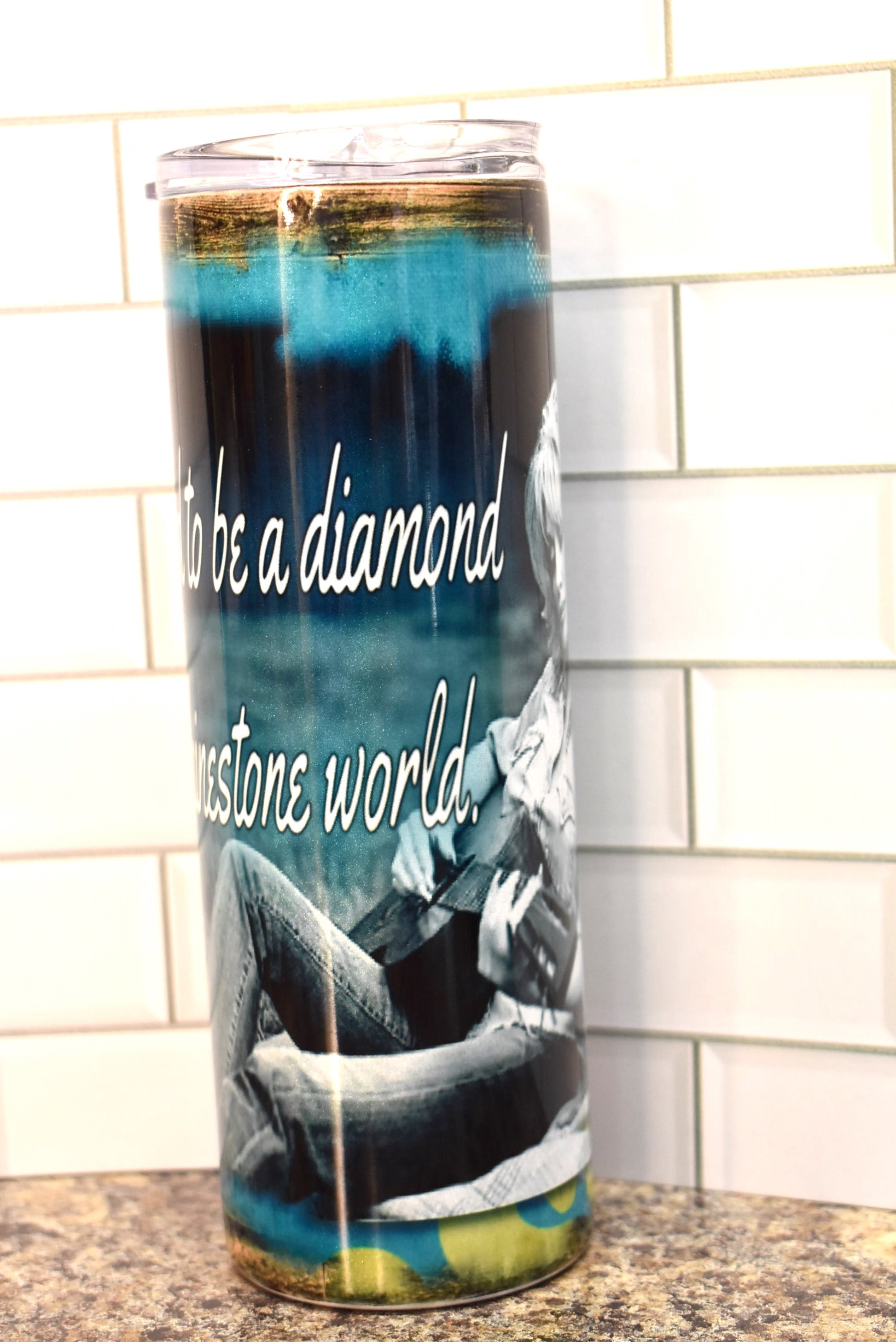 This 20 oz stainless steel Makerflo tumbler features the 1 and only Dolly Parton as she plays a guitar with the phrase....It's hard to be a Diamond in a Rhinestone World .