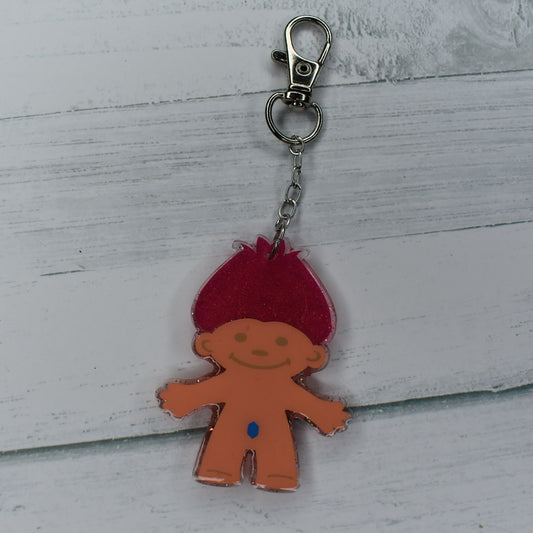 Take you back to the 80s and 90s on this one. Our Troll Doll with red hair and blue gem belly button Bag Tag will bring back fond memories