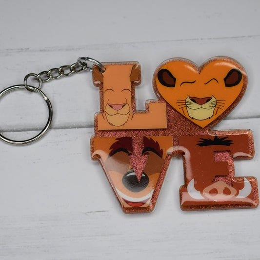 This stylish acrylic keychain flaunts a brown glitter base with Simba and friends in vinyl lettering - a perfect way to celebrate love!