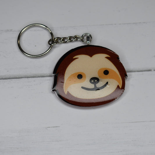 This Keychain showcases a jolly sloth with a bright grin. With a sparkly white back and a cheerful sloth on the front, this keychain is crafted from sturdy, long-lasting acrylic resin.