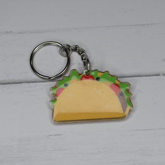 The Taco keychain allows for enjoyment of tacos any day, not just Tuesdays. It is expertly handcrafted with durable acrylic resin, ensuring long-lasting quality.