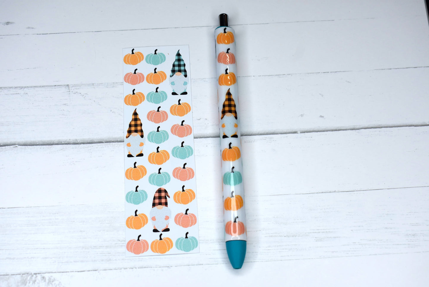 This Gel Pen has an Epoxy Resin finish, featuring a cute gnome among pumpkins in a orange teal & pink color scheme with blue ink and one extra black ink refill.