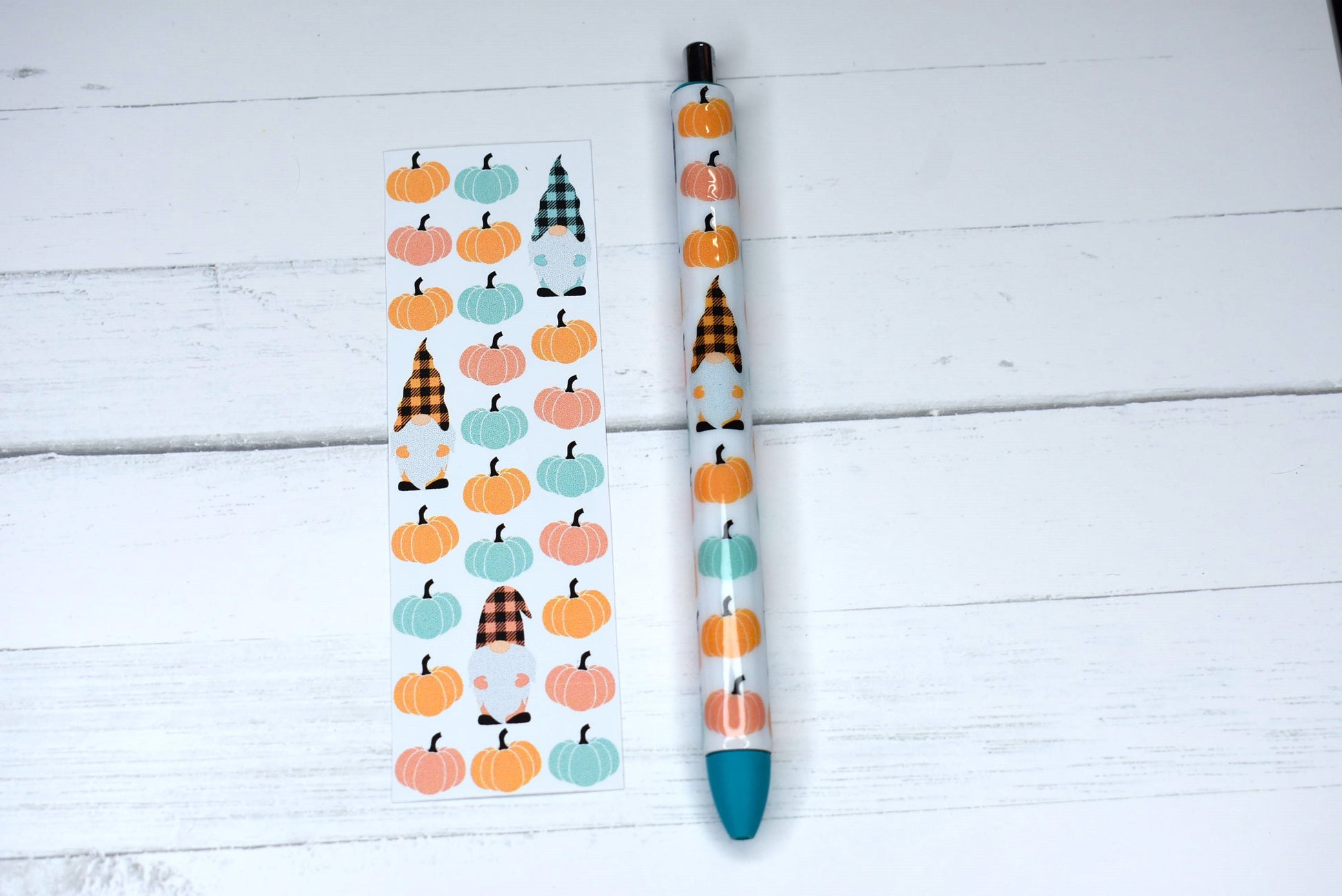 This Gel Pen has an Epoxy Resin finish, featuring a cute gnome among pumpkins in a orange teal & pink color scheme with blue ink and one extra black ink refill.