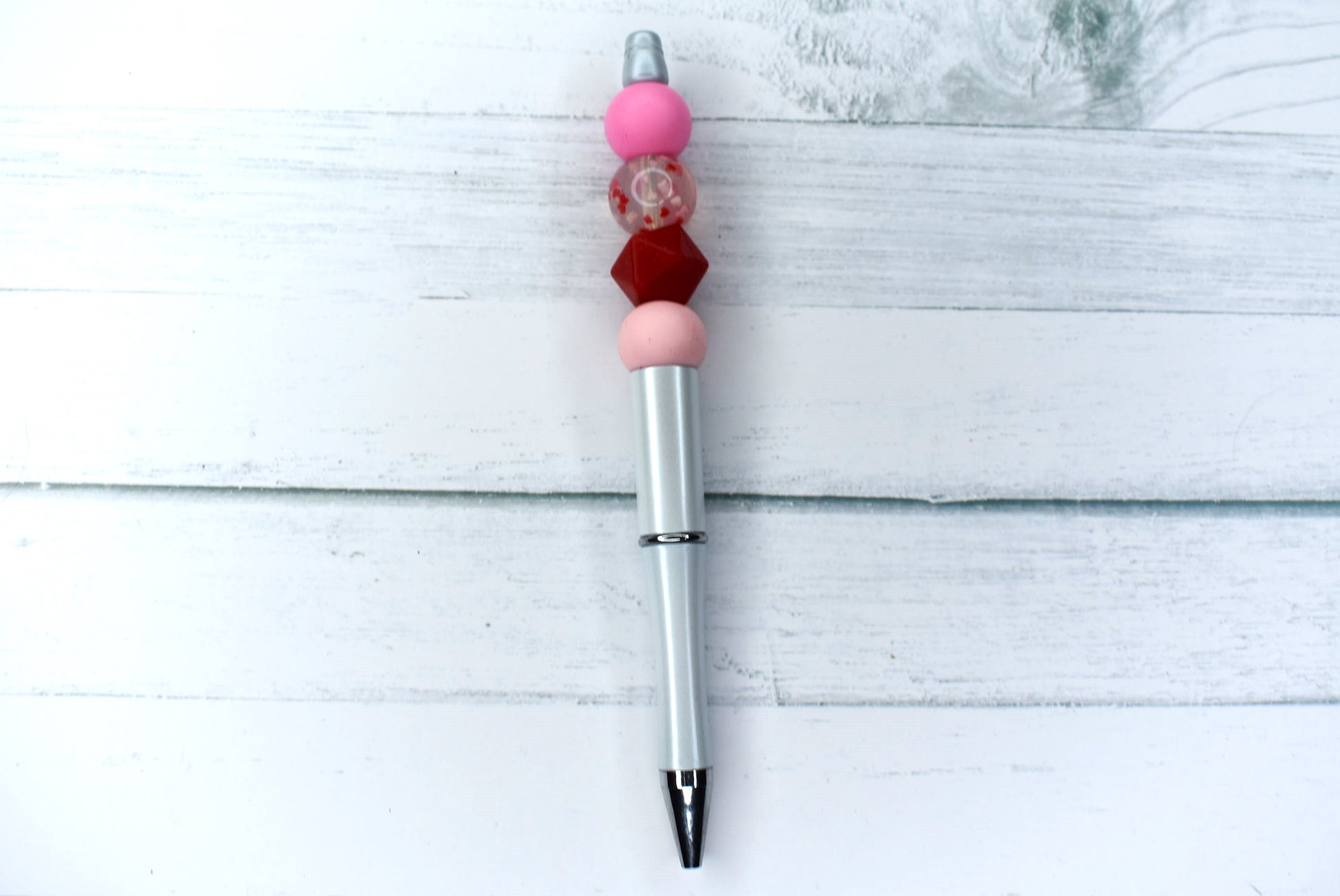 This clear silicone bead with floating hearts and a solid pink bead with white base will surely have you loving this pen. Comes with 1 extra refill.