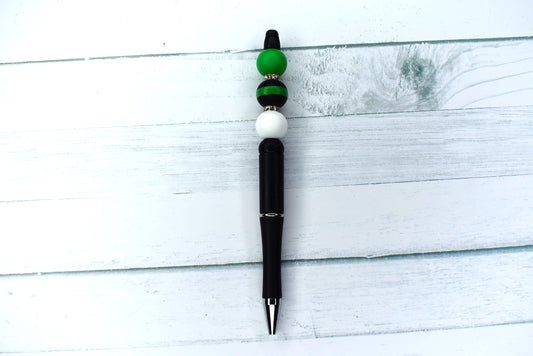 This silicone beaded pen features a black base, white & green silicone accent beads and a black bead with a green stripe. 1 extra black ink refill also included