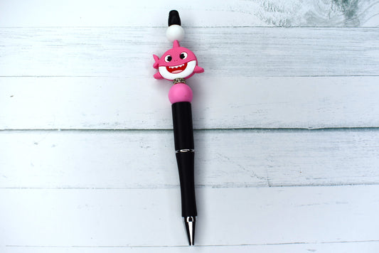 The waters are safe with the Baby Shark in. Mommy Shark tops this silicone beaded pen with white & pink accent beads and a sparkling gem ring. A black base completes the look. 1 extra black ink refill included.