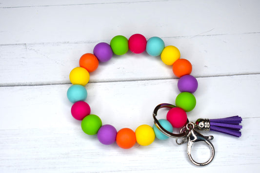 This keychain wristlet is constructed with silicone beads in a vibrant combination of hues and accompanied with a faux leather tassel.