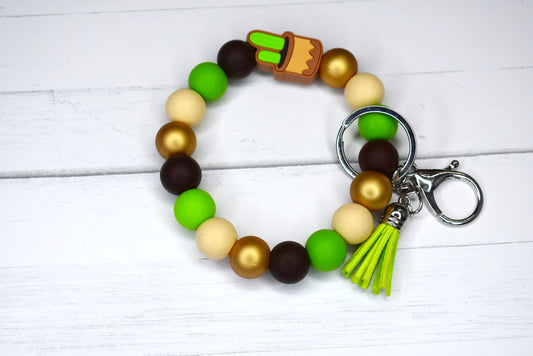 From the Western Desserts we bring you this cute cactus Wristlet keychain made from silicone beads with a potted cactus focal beads and a faux leather tassel.