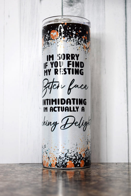 This 20 oz stainless steel Makerflo tumbler features colorful background image with a white splatter paint section with the phrase I'm Sorry If You Find My Resting Bitch Face Intimidating I'm Actually A Fucking Delight. 