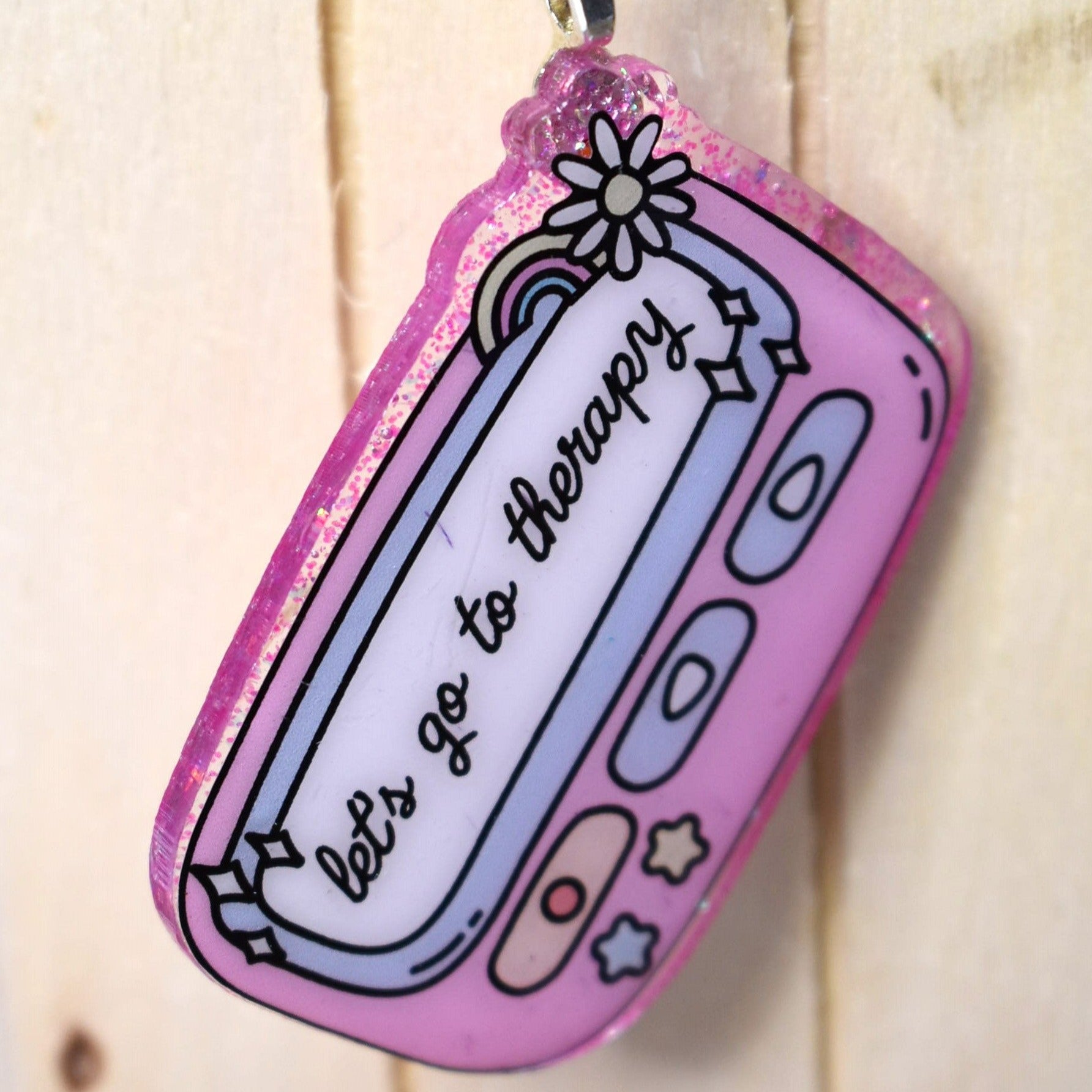 Keychain Lets Go To Therapy is crafted from durable acrylic resin and comes in pink or purple. Perfect for those in need of some therapy on the go.