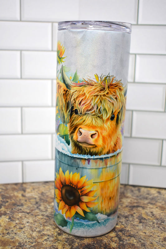 This adorable Highland Cow calf is all lathered up taking a bath in a large bucket surrounded by sunflowers & butterflies. 