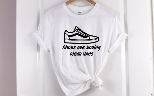 Our T-shirt features a Screen Print Transfer of black lettering with the phrase "Shoes Are Boring Wear Vans." This Unisex adult-sized shirt is made of 5.3 oz. of pre-shrunk 100% cotton.